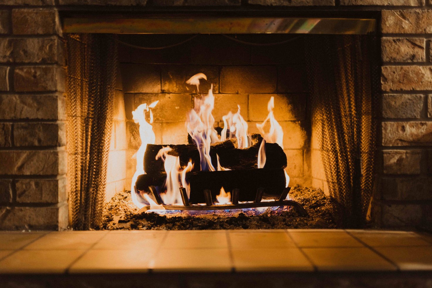 Image of logs burning inside a fireplace.